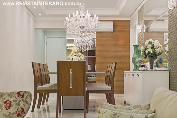 Madeira, espelhos e lustre de cristais (Casa Luz) compõem o jantar, com mobiliário da P.O. Móveis e Estofados e painel da Todeschini. O piso em porcelanato claro (Casa dos Construtores) e a pintura off-white nas paredes (Sotintas) ampliam visualmente os ambientes, que receberam pitadas de cores dos acessórios (DKasa Interiores)