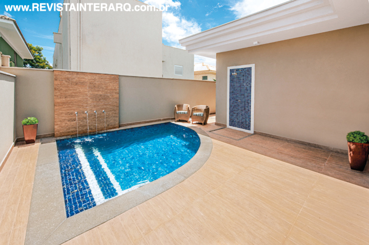 A piscina com fonte e três tons de pastilhas é puro charme. No piso, porcelanato da Portobello Shop
