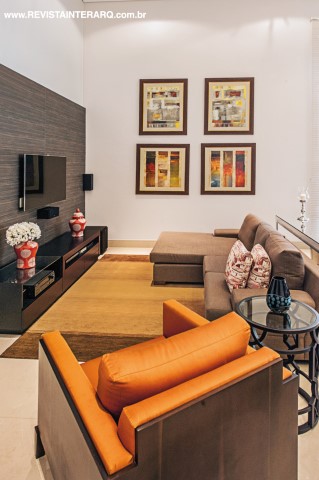Na área do home theater, o móvel desenhado pelo profissional é em laca preta e padrão madeira. O toque de cor ficou por conta das telas e das poltronas em seda laranja da Sierra UneRobusti