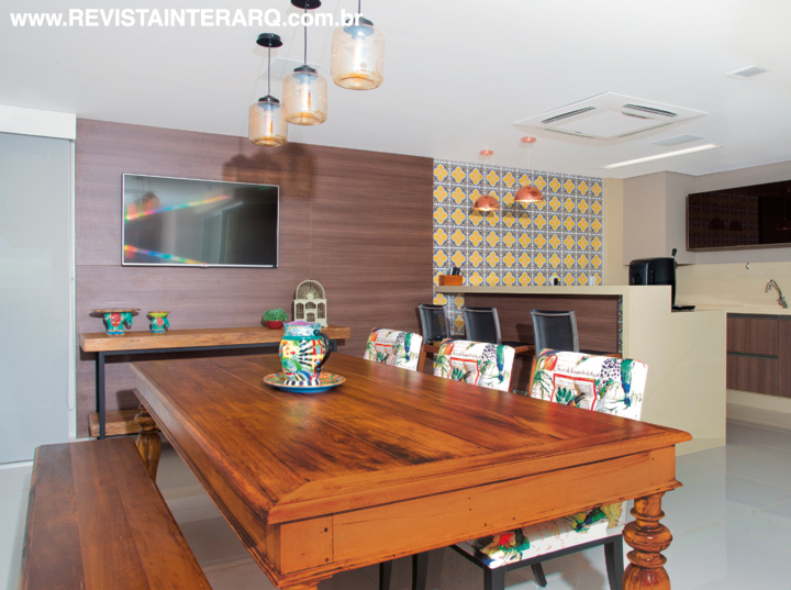 Mais descontraída, a varanda gourmet (no alto e à esquerda) teve a parede da área da cozinha revestida com cerâmicas pintadas à mão. A bancada em Silestone bege foi finalizada com móveis planejados amadeirados (Florense)