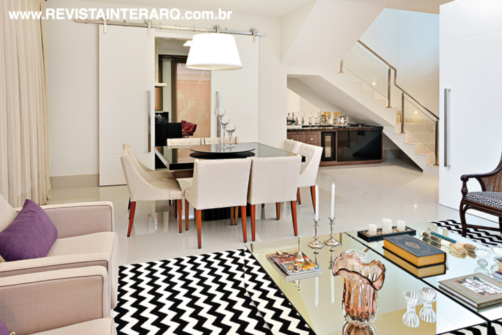 A sala de janta tem mesa da Robusti, cadeiras estofadas em linhão e objetos de decoração da Casa Verão