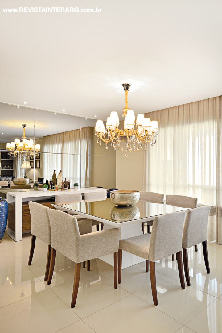 No jantar, a parede com espelhos acobreados duplica a composição com mesa e cadeiras da Robusti sob o lustre com mini cúpulas (Luminá Iluminação). Objetos de decoração da Casa Verão