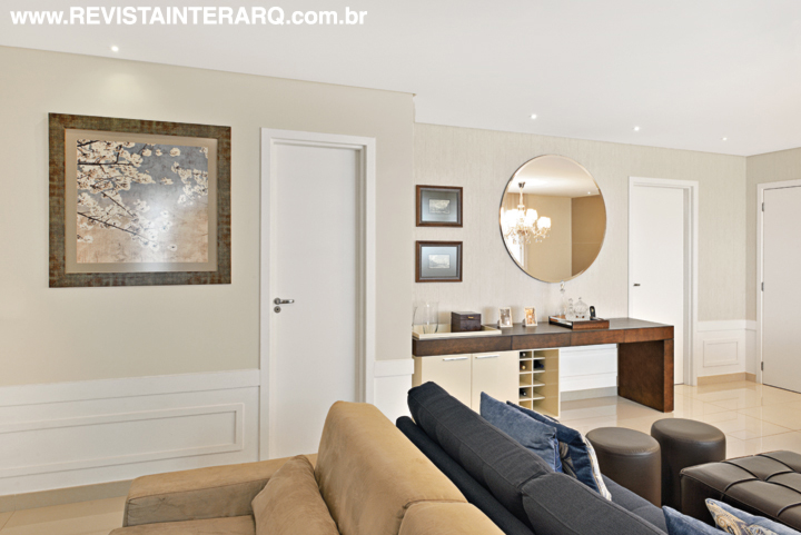 Os ambientes de estar e TV foram conectados por um generoso tapete (Bidjar Tapetes) e pelos acabamentos neutros, como o piso em porcelanato (Portobello Shop), a pintura clara e o rodapé alto com trabalho em gesso