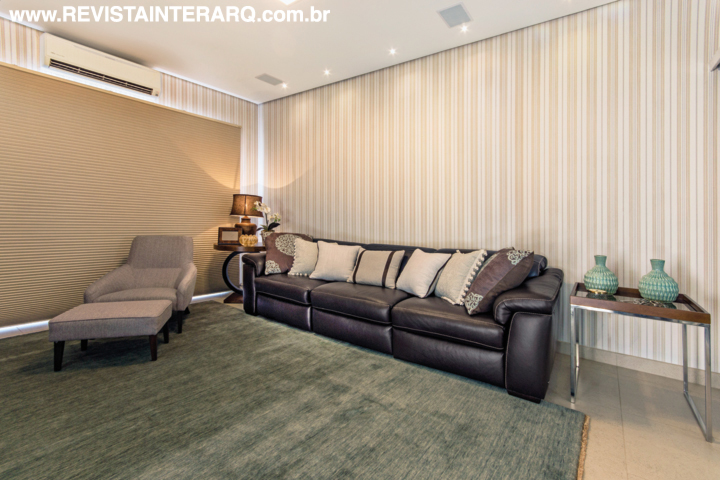 O home theater traz a mesma linguagem do living, com tapete da Bidjar e papel de parede e persiana da ACB Casa. Chaise e estofado em couro da UneRobusti