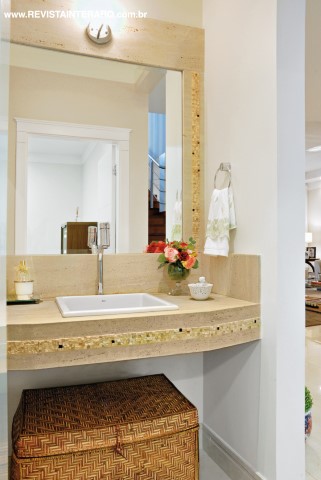 A bancada e a moldura em mármore trabalhado conferem charme ao lavabo