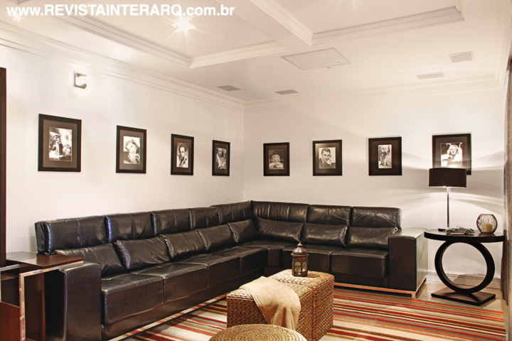 Cenas de clássicos do cinema foram emolduradas para inspirar as sessões pipoca no home theater. O sofá em couro preto em “L” faz contraponto aos pufes em fibra de bananeira (UneRobusti). A iluminação pontual (Luminá Iluminação) foi embutida no forro de gesso