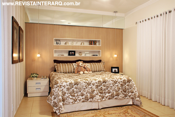 Na suíte da filha, a delicadeza do enxoval florido e papel de parede listrado. O painel de madeira com nichos (Florense) exibe os objetos decorativos (Casa Verão). Piso da Portobello Shop
