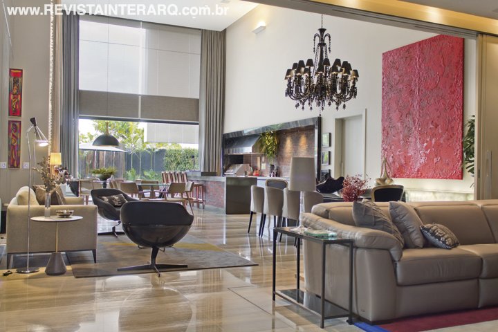 O home theater com sofá Natuzzi (Perfil Casa) pode ser setorizado por portas de correr (Rossi Sbrogio). Todo o piso é em mármore Grey Sandle (Villa Pietra). Cortinas da Tenda Decorações e automação da casa toda da Home Systems