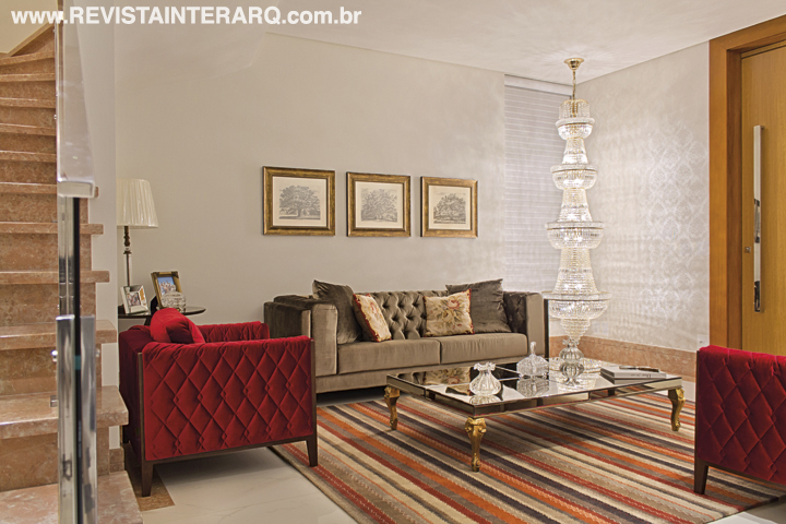 O incrível lustre de cristais (Projeto Led) faz as vezes de escultura luminosa no canto do living, decorado com sofá e poltrona da Decorativa