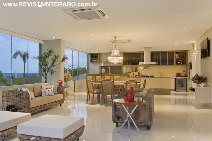 No espaço gourmet climatizado, o piso em porcelanato claro (Portobello Shop) ressalta o aconchego dos móveis em madeira e fibra (Decorativa). Na área da churrasqueira, armários da Decora Móveis e lustre da Projeto Led