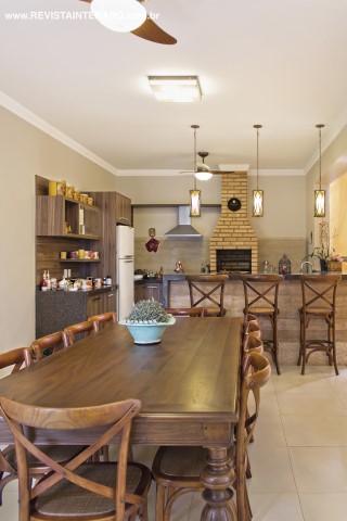 A madeira predomina na despojada área gourmet, tanto nos armários planejados (Todeschini), quanto nos revestimentos que imitam o material (Casa dos Construtores). As luminárias pendentes são da Casa Luz