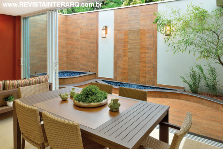 Na decoração, a praticidade dos móveis em alumínio e fibra sintética (Copav), posicionados junto às portas de alumínio que se abrem para o jardim com Spa e espelho d’água