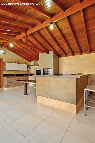 O espaço gourmet com pé-direito duplo e paredes de tijolos conta com a praticidade do piso em porcelanato da Portobello Shop e balcão em granito (Marmoraria Exclusive). Os armários amadeirados são da Florense e as banquetas, da Copav. Pintura da Tintas e Texturas Maggicor. O projeto arquitetônico é de Estevam Costa 