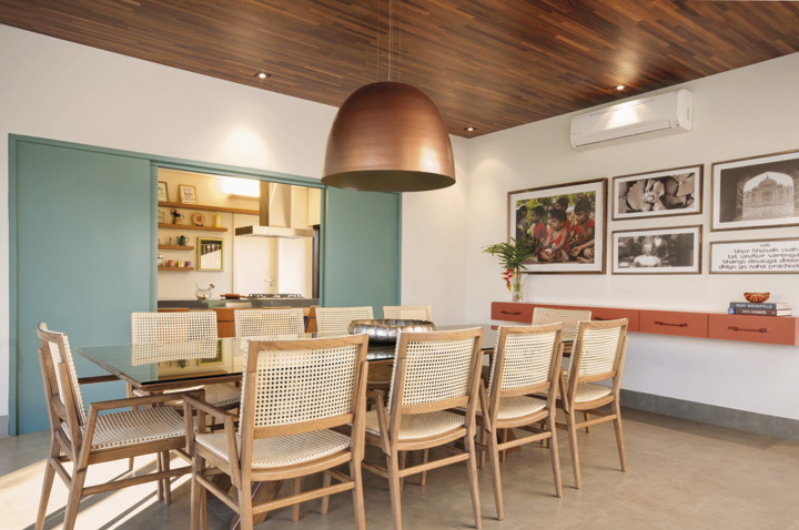 Um painel em laca verde setoriza ou integra o ambiente. O piso em porcelanato em tons de concreto foi padronizado em toda a casa.