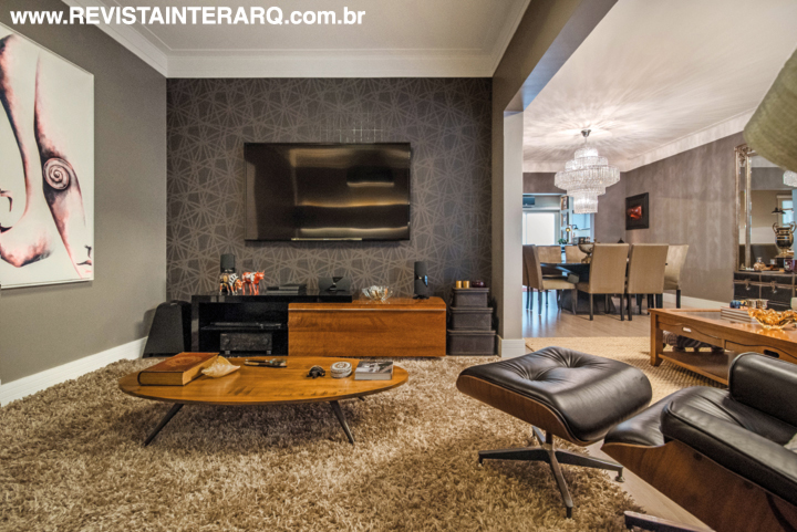 Ao lado do estar, o home theater automatizado ganhou iluminação cênica e papel de parede rendado cinza escuro compondo com a pintura cor Cinza (Depósito das Tintas).