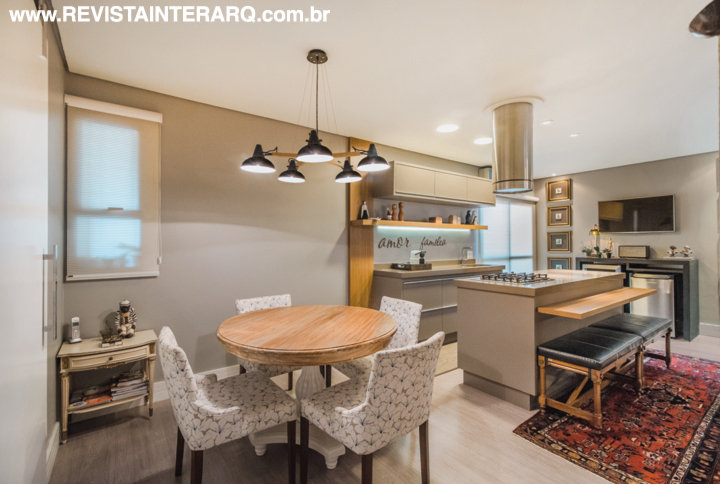 A cozinha gourmet encanta com os planejados escuros com detalhes em prata envelhecida, poltronas confortáveis e com a frase em ferro fundido, destacada pela iluminação de Led. Luminária da Ponto de Luz