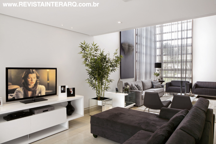 O social tem uma paleta que passeia entre o cinza e o bege com interferência do sofá berinjela e poltronas (tudo Decorativa)