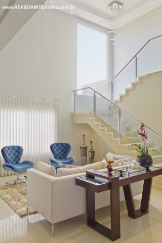 No amplo living revestido com porcelanato polido (Casa dos Construtores), a decoração é clean. A escada ganhou leveza com o corrimão em aço inox e vidro (LA Corrimão)
