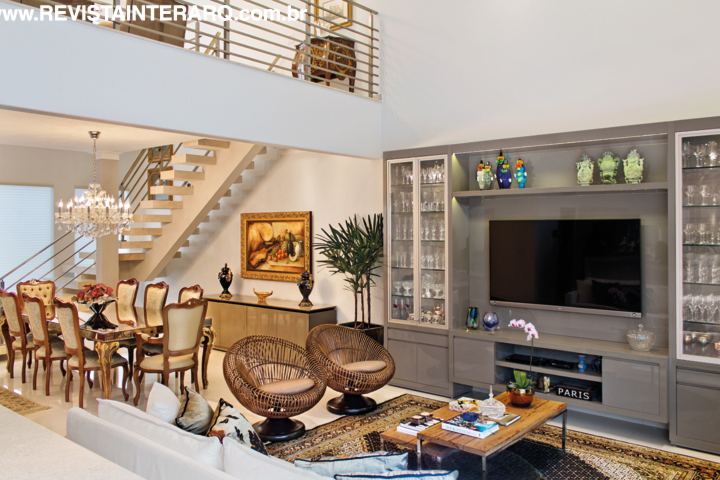 O móvel da TV desenhado pelas profissionais funciona também como cristaleira. Mesas de madeira e poltronas de fibra da Perfil Casa. Mais clássica, a sala de jantar combina lustre de cristal (NR Iluminação) com mesa e cadeiras da Decorativa