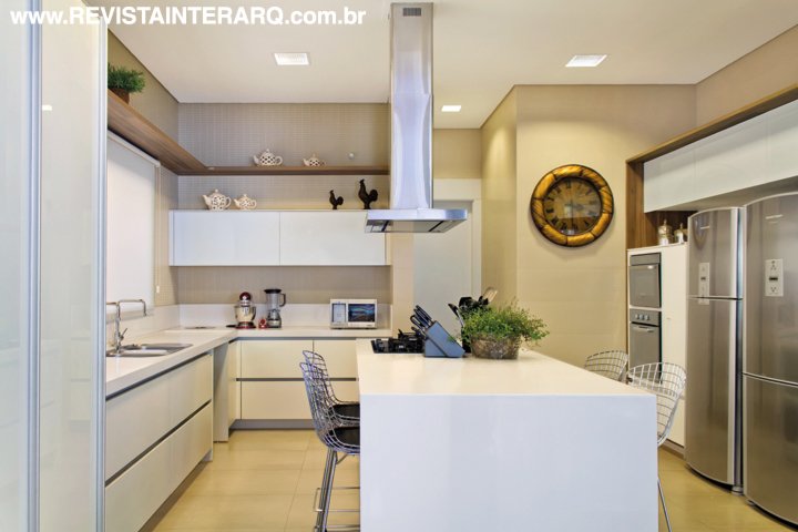 Linhas retas e branco total definem a marcenaria planejada da cozinha. Para completar, piso em porcelanato da Portobello Shop, bancada em Caesarstone (Stone Center) e banquetas Bertoia (Perfil Casa). Toda iluminação é da MM Iluminação. Coifa da Refrigeração Araçatuba