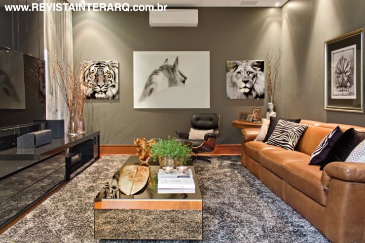 O home theater, mescla sofá de couro da Natuzzi (Perfil Casa), papel de parede escuro (Tenda Decorações), mesa espelhada (Jackie Móveis) e móvel em laca preta da Ismael Gabriel Marcenaria. O piso e rodapé em madeira são da ArtParquet