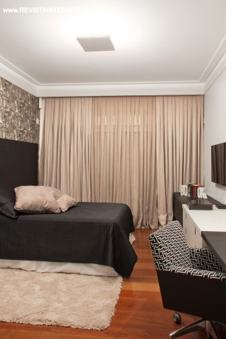 Quarto e saleta com TV giratória compõem a suíte do casal, que tem piso em réguas de madeira, tapete Aubusson by Cláudia Queiroz (Decorativa) e cabeceira estofada em capitonê de seda Dupion. Destaque para o visual intimista, resultado da iluminação indireta. Aparador da Roso Móveis