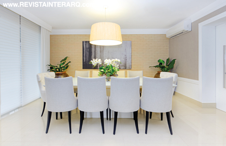 A parede em tijolos de demolição claros confere bossa ao jantar, decorado com mesa em laca off White (UneRobusti) e cadeiras em tecido de linho rústico. Nos vasos em cerâmica vietnamita, dois Pacovás, espécies indicadas para áreas internas (Spagnhol Plantas Ornamentais). O pendente em tecido plissado foi feito sob encomenda pela Luminá Iluminação. Piso em porcelanato brilhante da Portobello Shop