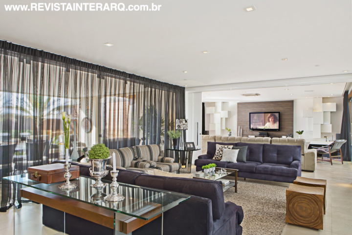 Portas de vidro (Votu-Box) integram o lazer ao living, ambientado com estofados em suede e bancos em madeira maciça (Decorativa). As cortinas de voil são do Paraíso dos Carpetes. Piso da Portobello Shop
