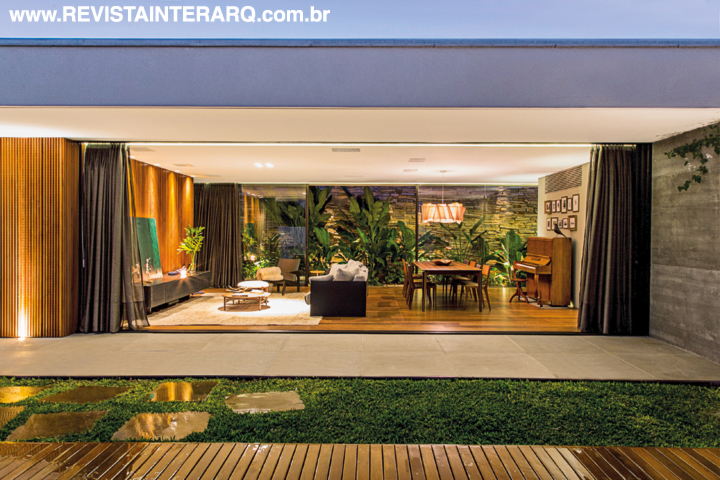 Para o living, a escolha foi pelo aconchego da madeira no piso da Indusparquet (Marcello Revestimentos) e parede. Objetos de decoração da Casa de Cora e tela verde da artista plástica Deise Pucci. A execução da obra ficou a cargo da construtora Vila Romana Engenharia