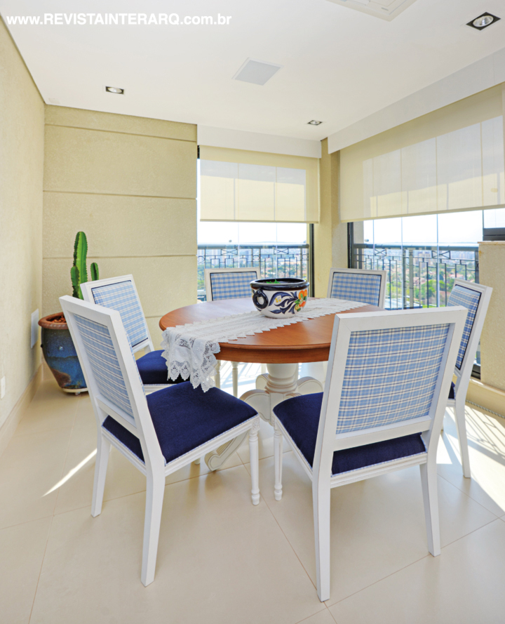 Os tons de azul e amarelo predominam na varanda gourmet, charmosa com a mesa provençal (Roberto Chaim) e cadeiras estofadas em tecido xadrez (ACB Casa). Protegido por persianas (ACB Casa), o espaço conta ainda com vaso com cactos (Spagnhol Plantas Ornamentais) e sofá marinho (UneRobusti)