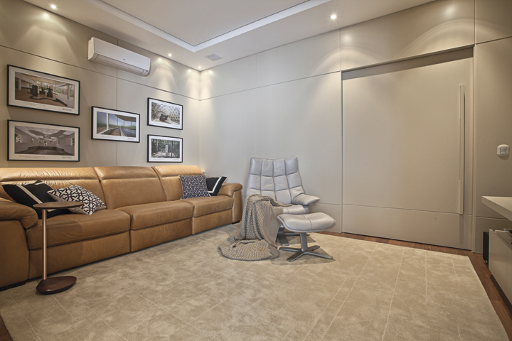 O home cinema foi todo revestido com painéis em marcenaria laqueada e decorado com estofados italianos