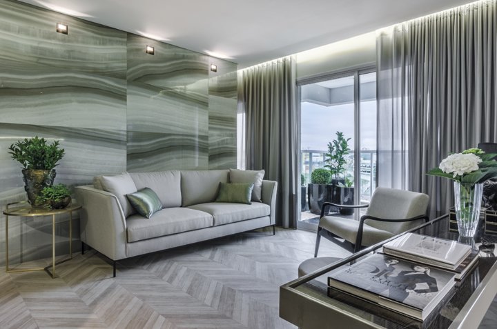 O projeto foi inspirado nos apartamentos parisienses com base clássica e decoração limpa e contemporânea. Entre os destaques do design de interiores está o porcelanato da linha mármore em uma das paredes do living. O ambiente é integrado à varanda, transformada em um jardim