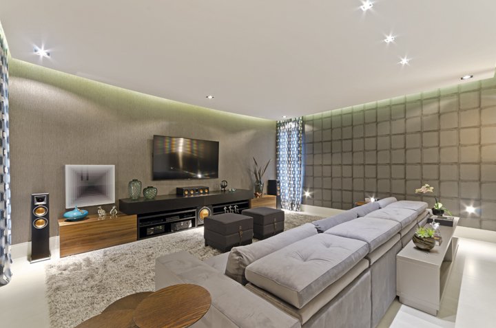 O home theater tem paredes com isolamento acústico e iluminação cênica para aprimorar os momentos de diversão