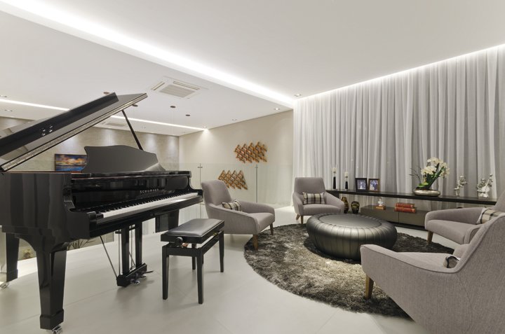 O mezanino acomoda o belo piano de cauda, uma das paixões dos moradores. O pequeno estar com poltronas confortáveis convidam a apreciar boa música