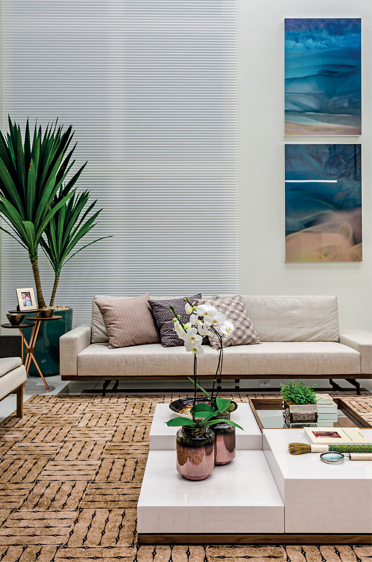 O pano de vidro amplo acompanha o pé-direito duplo do living, e acentua a luminosidade natural