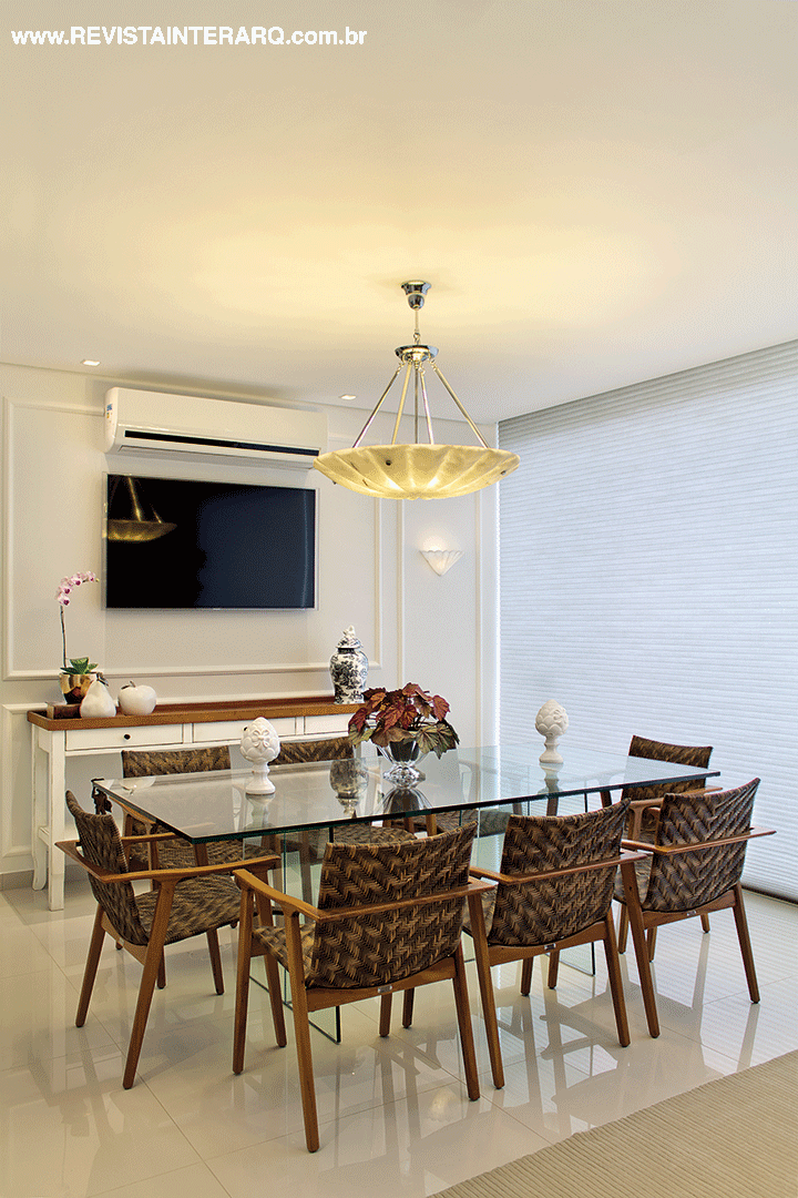 Na sala de almoço, descontração com aparador rústico, mesa de vidro e cadeiras da Perfil Casa complementados pela luminária em alabastro (NR Iluminação). Persiana Hunter Douglas da Griffe A