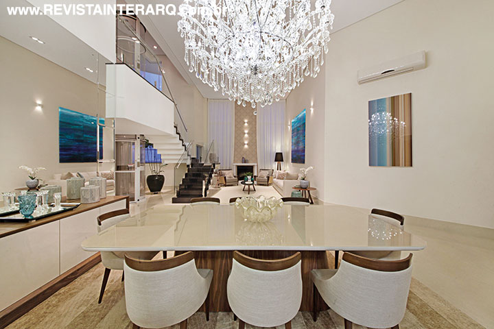 Detalhe da sala de jantar, com aparador sob medida (Galeria Top Kazza | Saccaro) junto à parede espelhada, mesa em vidro fendi e lustre de cristais