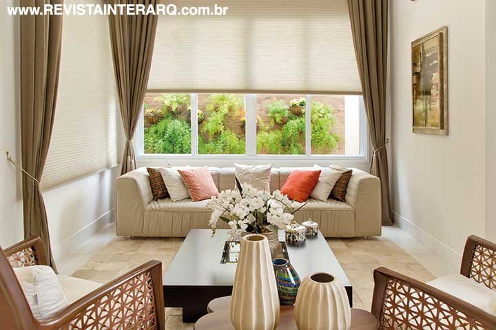 Cortinas plissadas motorizadas (Marcello Revestimentos) acompanham toda a altura do pano de vidro do living e permitem aos moradores escolher entre privacidade ou integração com o jardim vertical