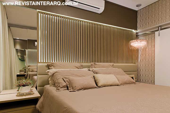 Na suíte máster, o painel ripado (Vinter Móveis) atrás da cama funciona como um grande “abajur” de iluminação indireta.