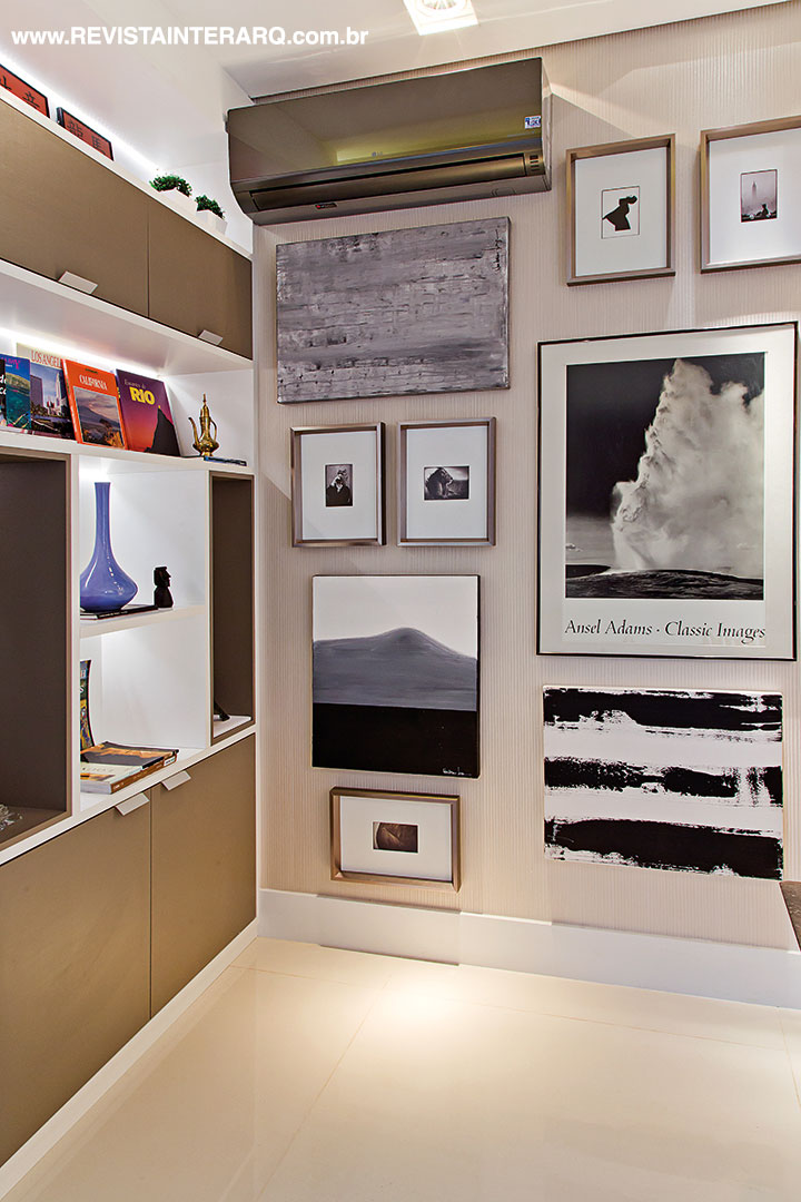 As telas compõem com as fotografias trazidas do Museu de Fotografia de Estocolmo. Na estante com iluminação embutida, os livros de Arte e Arquitetura preferidos da arquiteta. Esquadria de PVC da FScott e brises amadeirados Hunter Douglas da Marcello Revestimentos