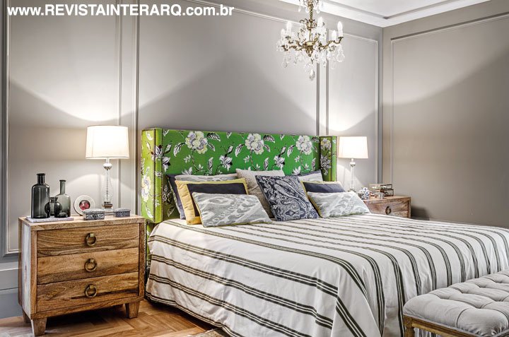 Boiseries e lustre de cristais evocam romantismo na suíte. A cabeceira personalizada em tecido da Entreposto verde faz par com a cômoda em madeira de demolição