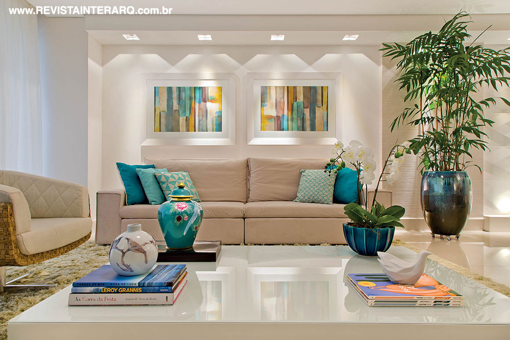 Paixão da moradora, os pássaros inspiraram o décor do living e aparecem em acessórios. As cores claras nos estofados e móvel da TV se uniram às tonalidades azuis, turquesas e verdes nas peças decorativas (Paredes) para conferir leveza. A palmeira (Mamãe Natureza) no vaso vietnamita azul (Stylo & Classe) finaliza a composição com frescor 