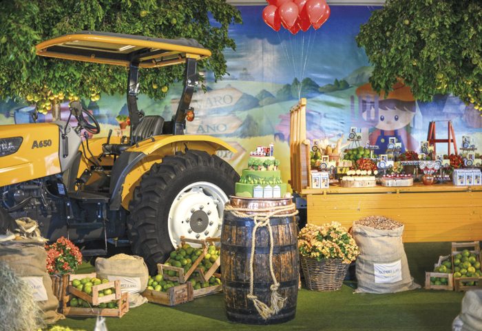 A carreta puxada por um trator Valtra, cedido pelo Mercadão dos Tratores, trazia os doces temáticos e esculturas personalizadas acomodados em louças (Slaviti) e suportes de madeira rústica. O painel com a paisagem bucólica (SilkTek Digital Print) ganhou “vida” ao emoldurar a laranjeira com frutos para colher