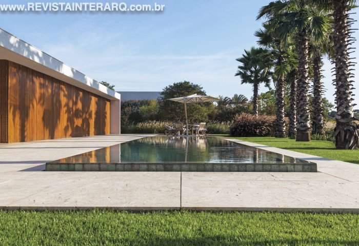Nesta casa de campo, o paisagismo brinca com a volumetria de maciços coloridos e palmeiras com 6 metros de altura - Revista InterArq | Arquitetura, Decoração, Design, Paisagismo e Lifestyle