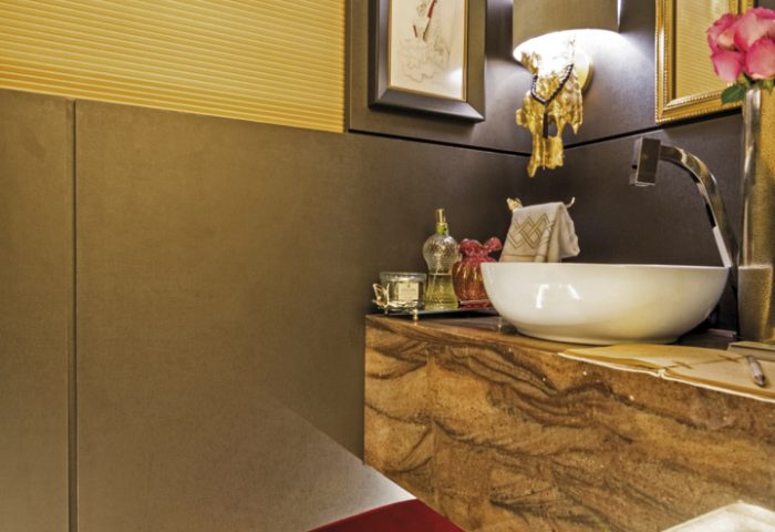 Márcia Meluci, no lugar do papel de parede, utilizou grandes placas de MDF decorado nas paredes e teto, o que trouxe, junto com o mármore da bancada, um ar nobre para o “Lavabo”.