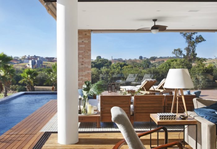 Este projeto da arquiteta Solange Cálio foi norteado pela integração visual entre living, varanda, piscina e a mata nativa que circunda um campo de golfe ao lado. Com arquitetura de traços contemporâneos, a casa ficou mais aconchegante com o despojamento dos tijolos aparentes e da madeira.