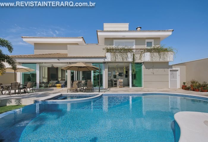 A piscina de linhas orgânicas, revestida com pastilhas da Portobello Shop, deram movimento à fachada do lazer, projetada por Ariana Basto Peres. Poltronas, chaises, ombrelones e mesas (Copav) acomodam com conforto aqueles que estão aproveitando o dia de sol na área da piscina. Grandes portas de vidro e alumínio (LA Esquadrias) levam à varanda gourmet.