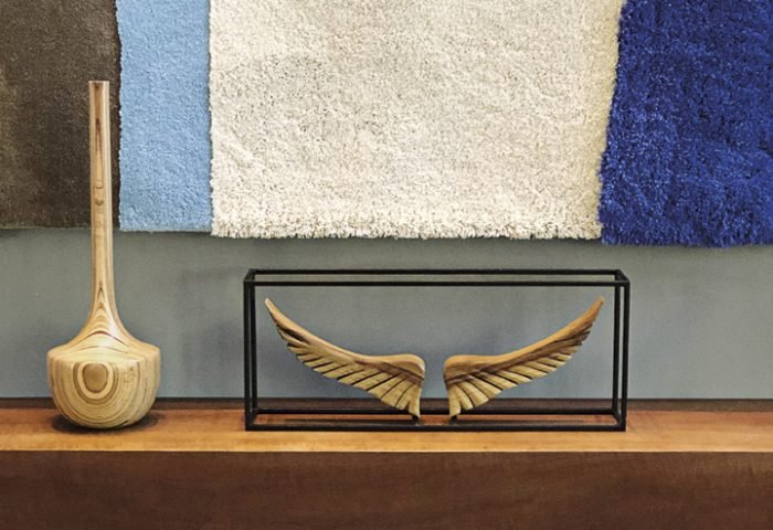 Aparador suspenso, escultura Asas de Davi e vaso assinados por Leonardo Bueno, artista plástico reconhecido pelo seu design único que mistura o rústico e o sofisticado. O tapete na parede é da Punto e Filo e foi desenhado por Rodrigo Ohtake . 