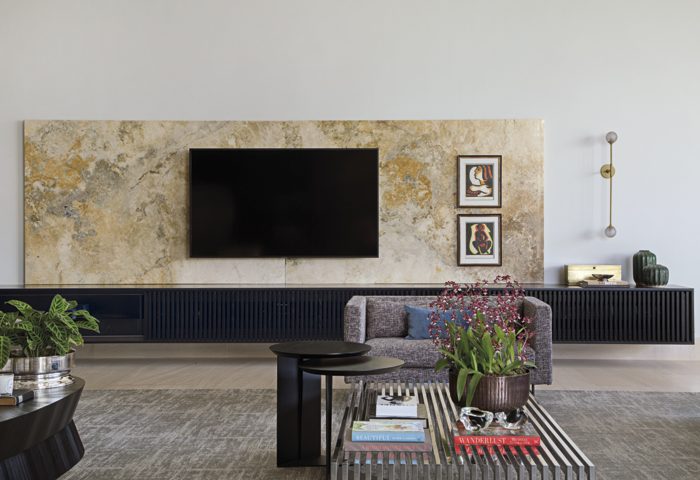 Outro ângulo do living recebeu painel em Limestone (execução Granitex), móvel de apoio (Marcenaria Cogui & Silva) para TV, telas de Di Cavalcanti, além de poltrona e luminárias assinadas por Jader Almeida (ambas Jackie Móveis)