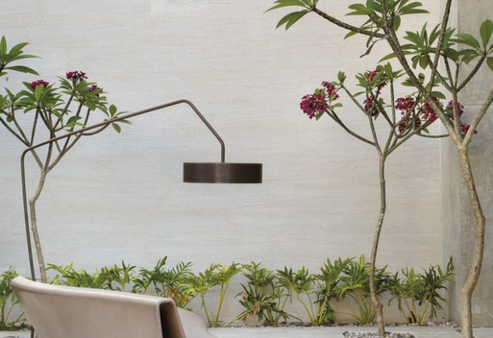 A área externa minimalista possui banco (Perfil Casa) e luminária da Lumilight